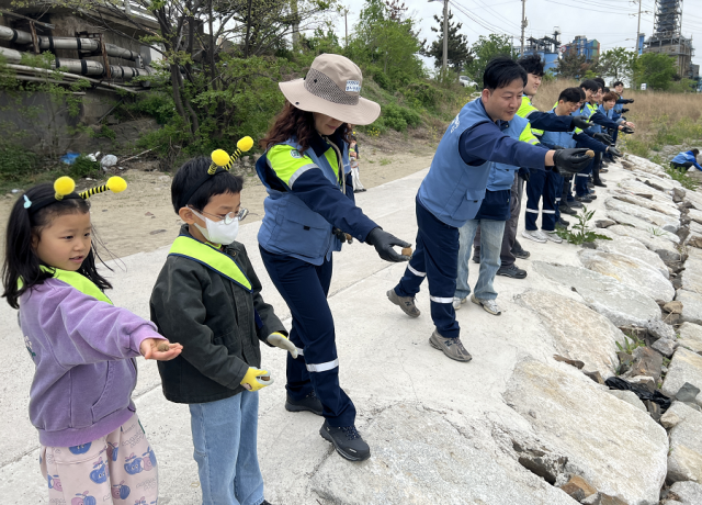 22일 퓨처엠 Nature Guard Day 봉사활동에 참여한 포스코퓨처엠 직원과 가족들이 씨드볼을 만들어 포항시 남구 냉천에 던지고 있다 사진포스코퓨처엠