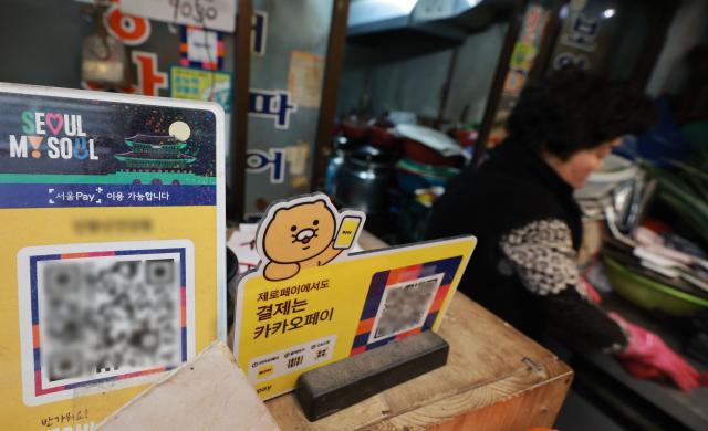 서울시가 오는 27일부터 기초생활수급자 차상위계층 한부모가족 대상 고유가 피해지원금 1차 신청을 받는다 서울 종로구 통인시장에 서울페이와 온누리상품권 등 안내문이 붙어있다 사진연합뉴스