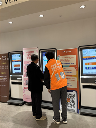 디지털동행파트너가 무인 발권기키오스크 사용에 어려움을 겪는 시민을 도와주고 있다 사진서울시