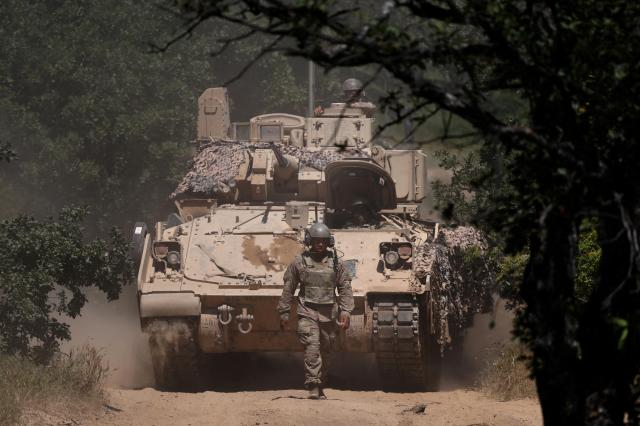 A US soldier walks in front of an armoured vehicle during Balkan Sentinel - 25 military drill an exercise involving personnel and equipment from the Bulgarian Land Forces and Air Force formations from the NATO Multinational Battle Group with Italy and a mechanized platoon from the Romanian Land Forces in Koren Bulgaria June 9 2025 Reuters-Yonhap 