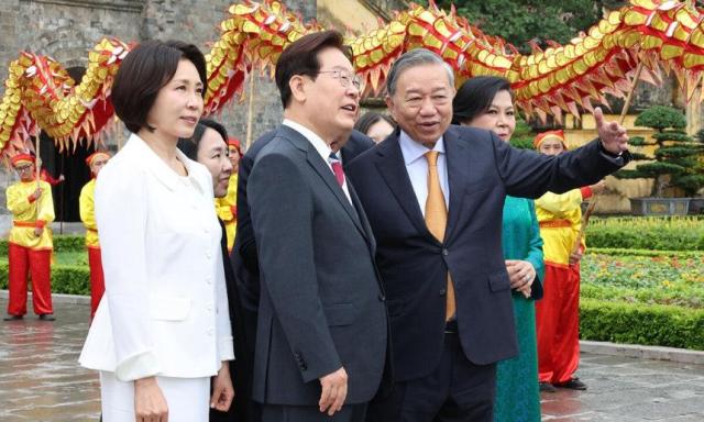 이재명 대통령과 김혜경 여사가 24일현지시간 친교일정을 위해 방문한 하노이 탕롱 황성에서 영접 나온 또 럼 공산당 서기장 겸 국가주석 부부와 환영공연을 보며 이동하고 있다사진연합뉴스