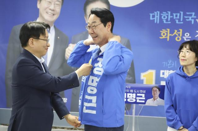 공동선대위 상임위원장 권칠승 의원이 정명근 후보에게 선거운동복을 입혀주고 있다 사진정명근 후보 사무소