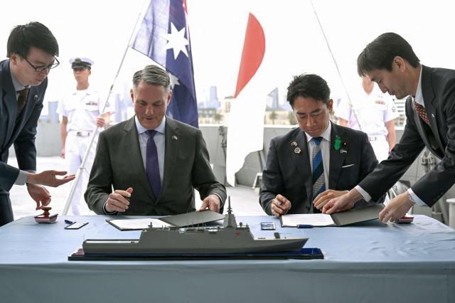 Australias Deputy Prime Minister and Minister for Defence Richard Marles second from left and Japans Minister of Defense Koizumi Shinjiro second from right sign the contract for Japan to deliver the first three of Mogami-class warships in Melbourne on April 18 2026 AFP-Yonhap