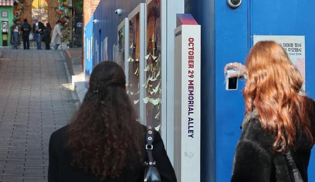 지난해 1029 이태원 참사 3주기를 하루 앞두고 서울 용산구 이태원역 1번 출구 인근 참사 현장에 마련된 1029 기억과 안전의 길 앞에서 외국인들이 현장을 살펴보고 있다 사진연합뉴스