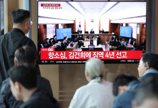 28일 서울역 대합실에서 시민들이 통일교 금품 수수와 도이치모터스 주가조작 명태균 무상 여론조사 등의 혐의를 받는 김건희 여사 항소심 선고공판 생중계를 시청하고 있다 사진연합뉴스