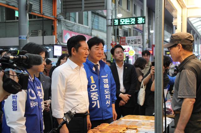 오중기 더불어민주당 후보와 정청래 대표가 포항 죽도시장을 방문해 민생 현장 행보를 이어가며 지역 상인들과 시민들의 목소리를 청취하고 있다 사진오중기 후보 선거사무소