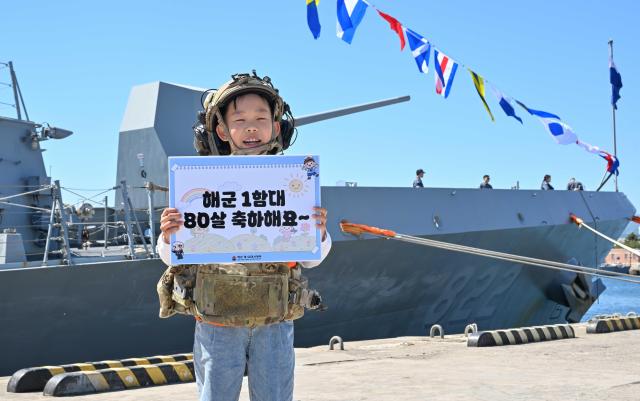 이번 부대개방행사에 참가한 어린이가 UDTSEAL 장비를 착용하고 동해함 배경 기념사진을 촬영하고 있다 사진해군1함대