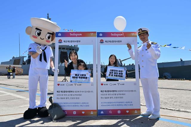이번 부대개방행사에 참가한 가족이 해군마스코트 이나비 해군 장교와 함께 1함대 창설 80주년을 축하하며 기념사진을 촬영하고 있다 사진해군1함대