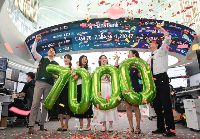 Employees at Hana Bank's dealing room in Jung-gu, Seoul, celebrate the KOSPI's historic close above 7000 on May 6. Photo by Yoo Dae-gil, dbeorlf123@ajunews.com
