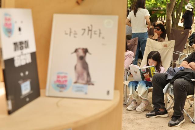 A child reads a book at an outdoor library during the Nami Island International Childrens Book Festival held on Nami Island in Chuncheon Gangwon Province May 10 2026 AJP Han Jun-gu