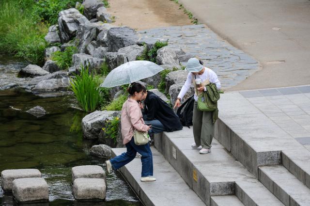 Citizens walk with umbrellas along Cheonggyecheon Stream in Seoul during rainfall on May 11 2026 AJP Yoo Na-hyun
