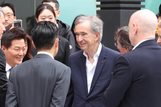 LVMH Chairman Bernard Arnault speaks with officials during a visit to the Shinsegae Department Store headquarters in Seoul May 11 AJP Han Jun-gu