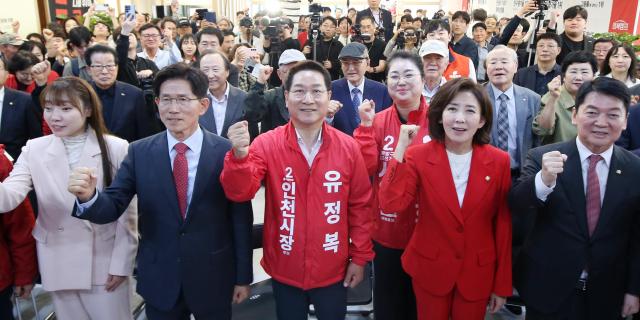 국민의힘 유정복 인천시장 후보가 12일 정복캠프에서 열린 개소식에서 내외빈들과 주먹을 쥐고인사하고있다 사진유정복 후보