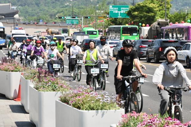 Climate activists ride bicycles through Gwanghwamun Square in Seoul to urge the National Assembly to promptly revise the Carbon Neutrality Act May 13 2026 AJP Han Jun-gu