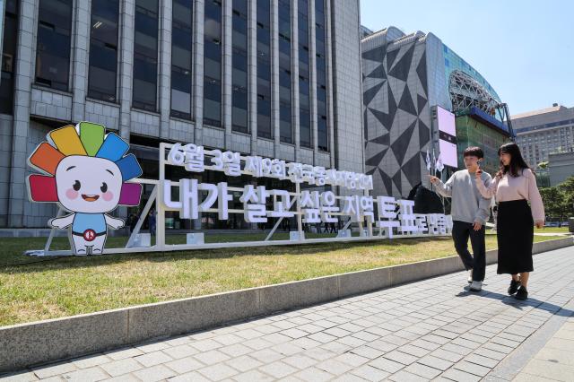 Election officials from the Seoul Metropolitan Election Commission promote voter participation in front of a public campaign sculpture for South Korea’s 9th nationwide local elections outside the Korea Press Center in Seoul’s Jung District on May 13 2026 AJP Yoo Na-hyun
