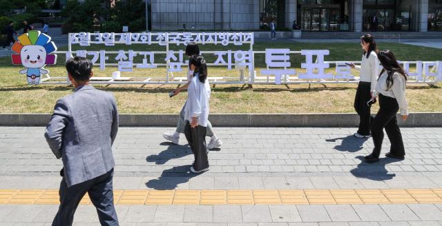 Election officials from the Seoul Metropolitan Election Commission promote voter participation in front of a public campaign sculpture for South Korea’s 9th nationwide local elections outside the Korea Press Center in Seoul’s Jung District on May 13 2026 AJP Yoo Na-hyun


