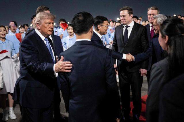US President Donald J Trump watches as members of his delegation including Tesla and SpaceXs CEO Elon Musk and Nvidia President and CEO Jensen Huang are greeted by Chinas Vice President Han Zheng and others as they arrive at the Beijing Capital International Airport on May 13 2026 AFPYonhap