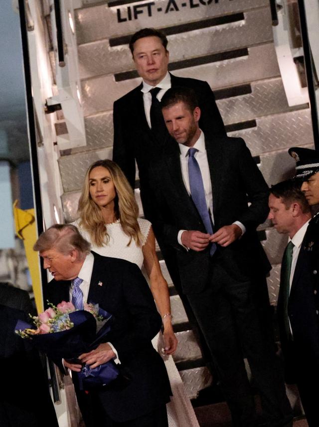 US President Donald Trump receives flowers next to Elon Musk Eric Trump and his wife Lara during an arrival ceremony at Beijing Capital International Airport in Beijing China May 13 2026 REUTERSYonhap