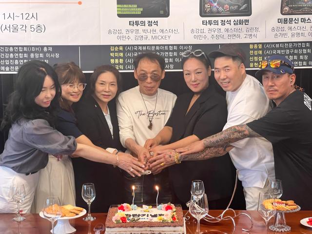 Participants at the book publishing event held by Korea Tattoo Associations Chairman Song Kang-seop are posing for a group photo with newly released Tattoo books AJP Joonha Yoo