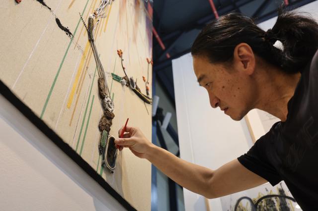 An artist works on an artwork at the Seoul Art Fair held at SETEC in Daechi-dong Gangnam-gu Seoul May 15 2026 AJP Han Jun-gu
