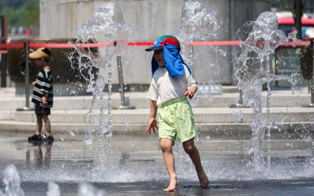 Citizens and foreign tourists cool off near the fountain at Gwanghwamun Square in Seoul on May 15 as daytime temperatures climbed to 32 degrees Celsius amid early summer heat AJP Yoo Na-hyun
