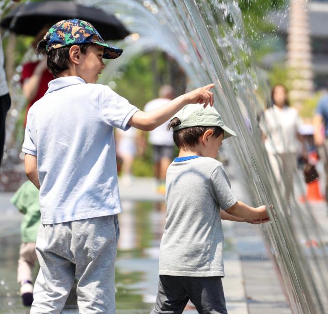 Citizens and foreign tourists cool off near the fountain at Gwanghwamun Square in Seoul on May 15 as daytime temperatures climbed to 32 degrees Celsius amid early summer heat AJP Yoo Na-hyun

