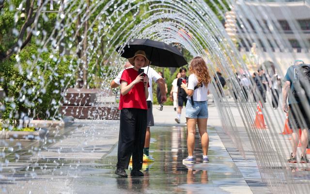 Citizens and foreign tourists cool off near the fountain at Gwanghwamun Square in Seoul on May 15 as daytime temperatures climbed to 32 degrees Celsius amid early summer heat AJP Yoo Na-hyun

