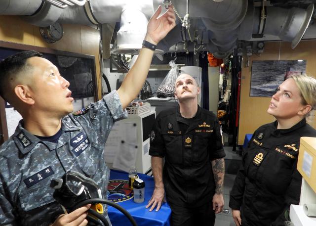 Oh Dong-gun executive officer of the South Korean Navy’s Dosan Ahn Chang-ho submarine explains onboard equipment to Lt Cmdr Brittany Bourgeois and Petty Officer Jake Dixon of the Royal Canadian Navy’s submarine command aboard the vessel on May 8 2026 Courtesy of the Republic of Korea Navy