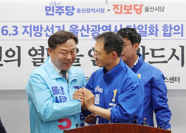 15일 울산시의회 프레스센터에서 더불어민주당 울산시당과 진보당 울산시당이 6·3 지방선거 울산시장 후보 단일화 합의를 발표한 후 김상욱오른쪽더불어민주당· 김종훈 진보당 울산시장 후보가 손을 맞잡고 있다 사진연합뉴스
