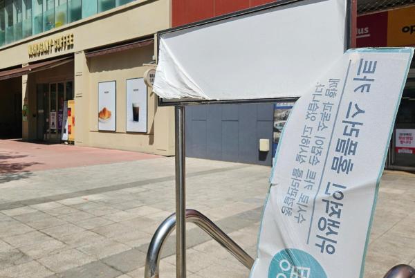 A torn sign flutters in the wind at the cart storage area of Homeplus in Jamsil