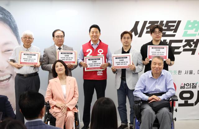 오세훈 국민의힘 서울시장 후보뒷줄 가운데가 19일 오전 서울 관철동 선거사무소에서 열린 서울시 장애인단체 정책간담회에서 각 단체가 전달한 정책 제안서를 들고 기념촬영을 하고 있다 사진오 후보 선거사무소