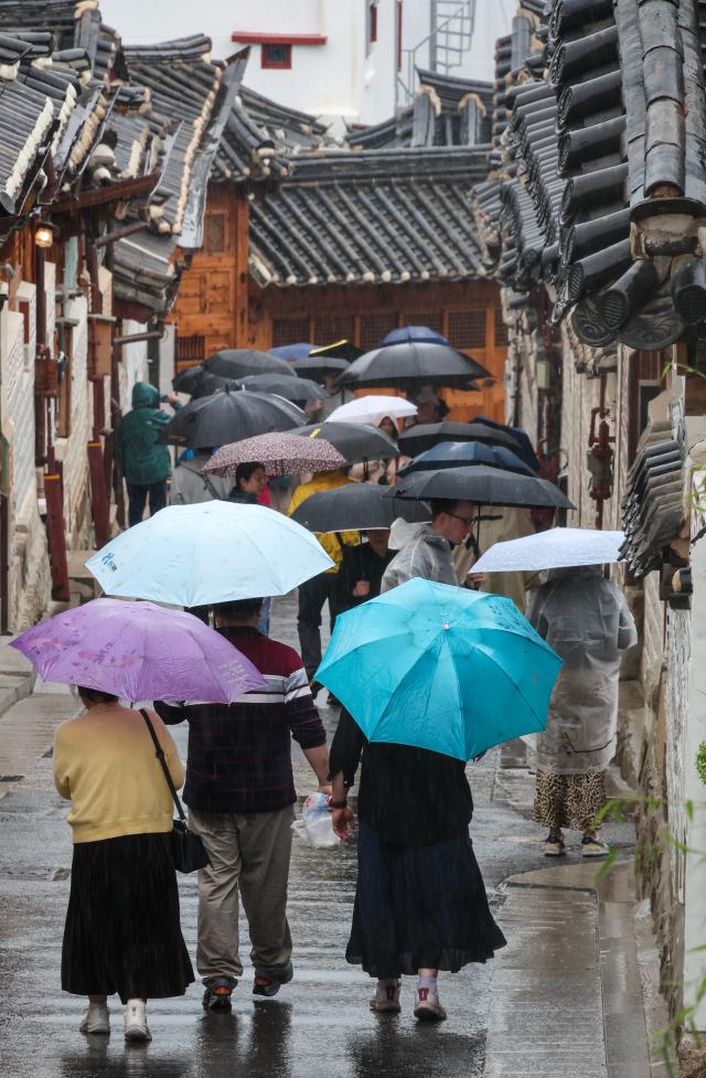 Tourists walk with umbrellas at Bukchon Hanok Village in Seoul’s Jongno District on May 20 as rain falls across the country AJP Yoo Na-hyun

