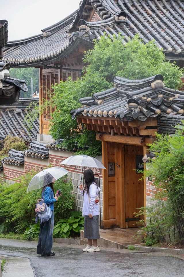 Tourists walk with umbrellas at Bukchon Hanok Village in Seoul’s Jongno District on May 20 as rain falls across the country AJP Yoo Na-hyun

