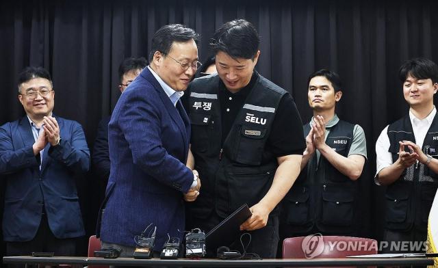 20일 경기도 수원시 장안구 경기고용노동청에서 열린 삼성전자 임금협상을 마친 후 여명구 삼성전자 DS디바이스솔루션 피플팀장과 최승호 삼성그룹 초기업노동조합 삼성전자지부 위원장이 잠정 합의안에 서명한 후 손을 맞잡고 있는 모습 사진연합뉴스