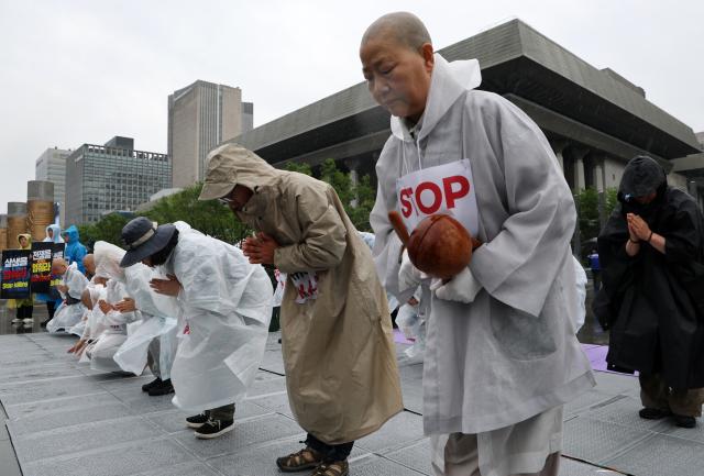 Buddhist monks and activists affiliated with the Jogye Order’s Social and Labor Committee perform 108 prostrations near the US Embassy in Seoul on May 20 2026 during a prayer event calling for peace in the Middle East under the slogan “Stop the War Let Peace Bloom” Yonhap
