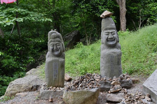 Stone figures marked with the Korean phrases “Do not hear” and “Do not speak” stand beside the trail at Hyangiram Hermitage in Yeosu South Jeolla Province on May 24 2026 AJP Joonha Yoo