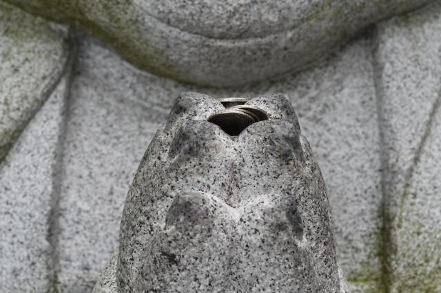 Coins rest in the hands of a stone Buddha statue at Hyangiram Hermitage in Yeosu South Jeolla Province on May 24 2026 AJP Joonha Yoo