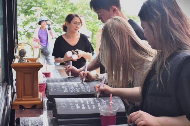 Visitors write wishes on roof tiles at Hyangiram Hermitage in Yeosu South Jeolla Province on May 24 2026 AJP Joonha Yoo