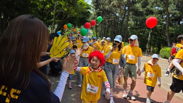 '2026 맥도날드 해피워크' 참가자들이 24일 인천 문학경기장 일대 하이파이브 존을 지나며 걷기 행사를 즐기고 있다. [사진=김현아 기자]