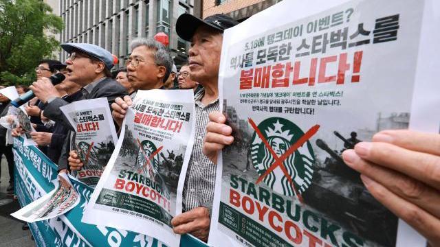 지난 21일 서울 종로구 스타벅스 광화문점 앞에서 5공피해자단체연합회 국가폭력피해범국민연대 박종철기념사업회 등 국가폭력 피해자 단체 주최로 열린 기자회견에서 한 참석자가 스타벅스 코리아의 5·18 민주화운동기념일 탱크 데이 프로모션을 규탄하며 스타벅스 불매 손팻말을 들고 있다 사진연합뉴스
