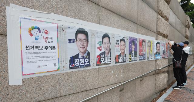 지난 21일 서울 중구에서 관계자들이 제9회 전국동시지방선거 벽보를 붙이고 있다 사진연합뉴스