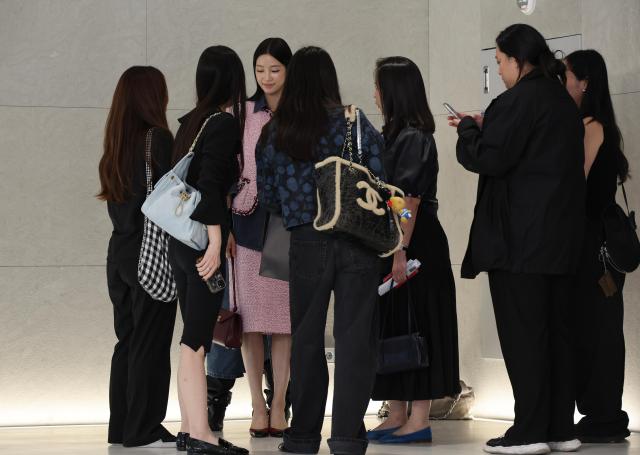 Chanel staff members check Kazuha of LE SSERAFIM’s outfit at the Chanel 2026 Métiers d’Art Collection Seoul show held at Pompidou Center Hanwha in Yeongdeungpo District Seoul on May 26 AJP Yoo Na-hyun