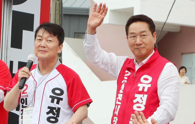 유정복 인천시장 후보가 27일 강화군 풍물시장 유세 현장에서 국민의힘 안철수 의원의 발언을 들으며 지지자들에게 인사하고 있다 사진유정복 캠프