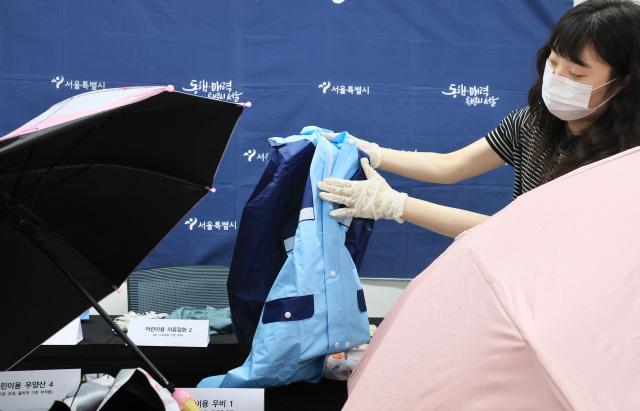 A Seoul city official displays products that failed overseas online platform safety inspections at Seoul City Hall on May 28 2026