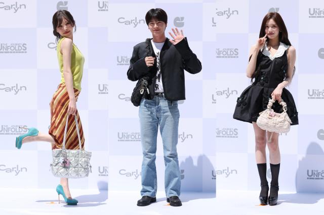 From left Wendy of K-pop girl group Red Velvet Yook Sung-jae of BTOB and Leeseo of IVE pose for a photo during the opening event for fashion brand CARLYNs Hongdae flagship store in Seoul on May 29 2026 AJP Yoo Na-hyun