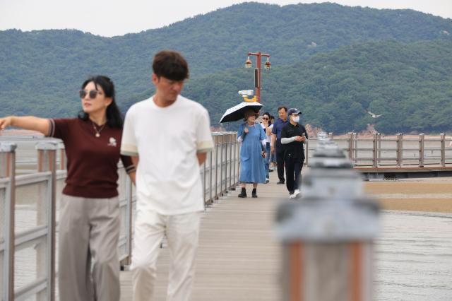 Visitors walk along the marine boardwalk at Hanagae Beach in Jung-gu Incheon on June 1 2026 AJP Han Jun-gu