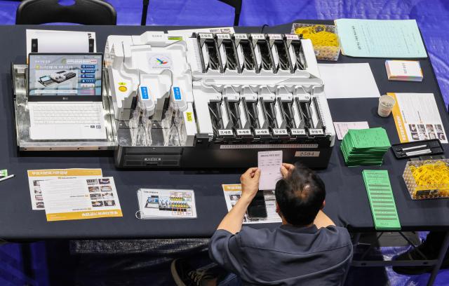Officials demonstrate a ballot sorting machine at a vote-counting center set up inside the gymnasium of Seoul National University of Science and Technology in Seoul on June 2 2026 one day before South Koreas ninth nationwide local elections AJP Yoo Na-hyun
