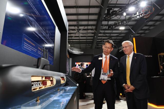 Hanwha Ocean Vice President Jung Seung-kyun left introduces the KSS-III submarine model to Ontario Economic Development Minister Vic Fedeli during CANSEC 2026 in Ottawa Canada May 27 2026 Courtesy of Hanwha Ocean
