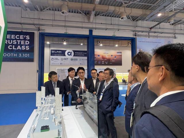 Visitors admire a model of an eco-friendly LNG carrier at the HD Hyundai Samho exhibition