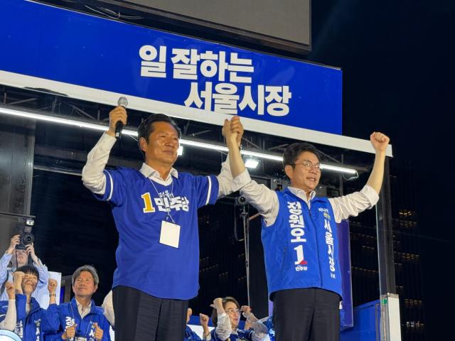 Jung Cheong-rae and Jung Won-oh raise their hands at the rally, showing their determination for victory